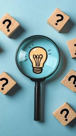 Concept illustration of a glowing light bulb under a magnifying glass among cubes with question marks symbolizes thinking and ideasの素材