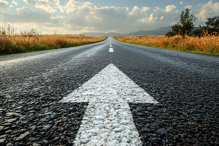 An asphalt road with an arrow painted on it symbolizes growth, development and the path to success.の素材