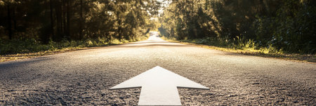 An asphalt road with an arrow painted on it symbolizes growth, development and the path to success.の素材