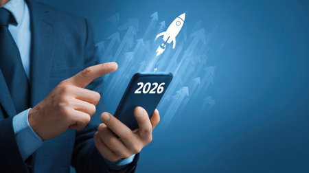 Businessman touches 2026 virtual numbers and rocket icon symbolizing business growth and innovation success.の写真素材