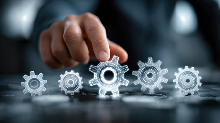 A businessman adjusts glowing holographic gears, symbolizing automation, teamwork, and advanced technology in modern industry.の素材