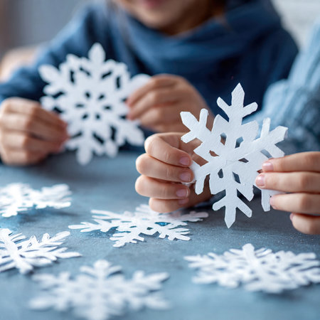 Children cut out paper snowflakes during holiday arts and crafts activities.の素材