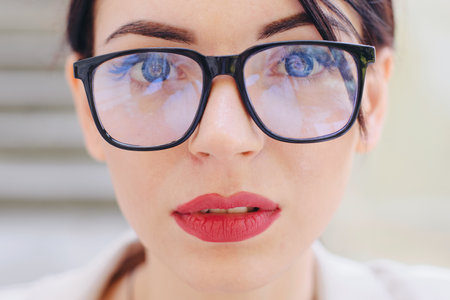 Close-up, the face of a young woman with glasses.