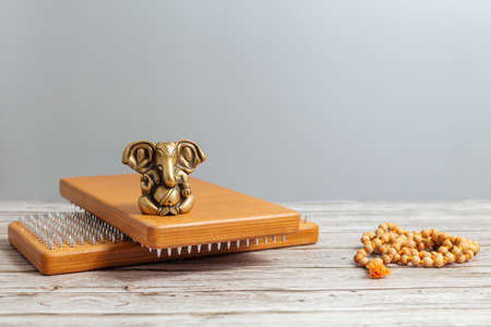 Bronze statue of Lord Ganesha, hindu God .. Brown Sadhu wooden boards with nails for yoga and...