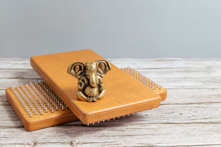 Bronze statue of Lord Ganesha, hindu God .. Brown Sadhu wooden boards with nails for yoga and...