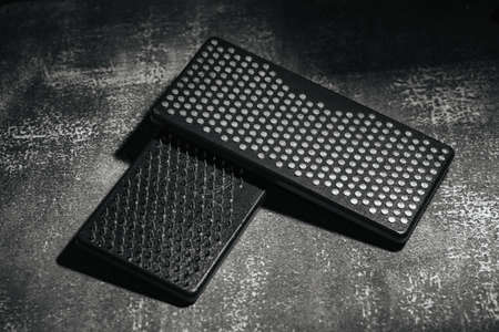 Black Sadhu boards for meditation, nails therapy, on dark background.