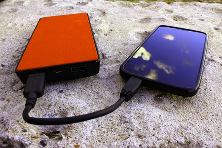 Brown powerbank and smartphone on concrete background, angle viewの写真素材