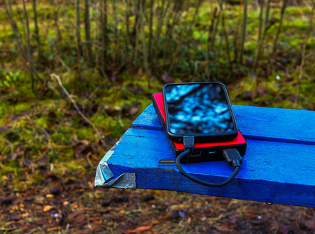 Smartphone and powerbank on a blue boardの写真素材