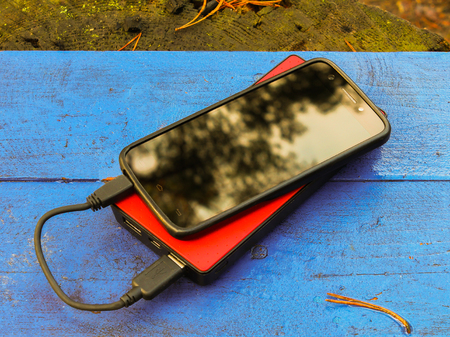 Smartphone and powerbank on a blue boardの写真素材