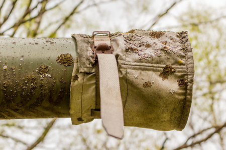 Green tank barrel with protecting cover and peacefullly covered with lichen or mossの写真素材