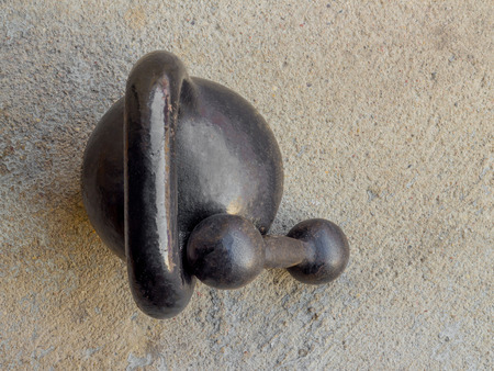 Old rusty black kettlebell 16 kg pood and small dumbbell on noncrete floor background top viewの写真素材