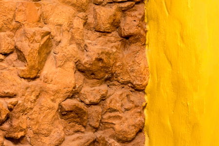 Bakground texture old brick stone wall and bright yellow painted wall with copy space for textの写真素材