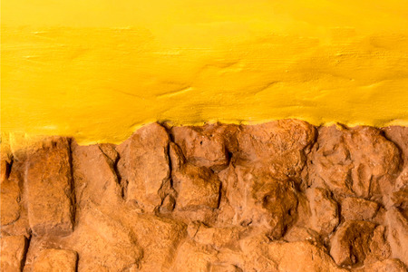 Bakground texture old brick stone wall and bright yellow painted wall with copy space for textの写真素材