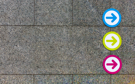 Three arrows blue green and pink on concrete wall background with copy spaceの写真素材