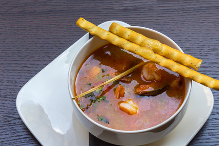 Delicious seafood soup with shrimps, prawns, oysters, mussels and jelly in a white soup plate on black table backgroundの写真素材