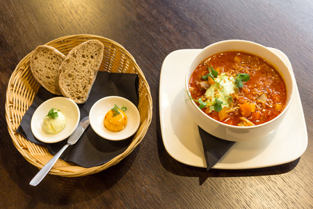 Goulash soup with lamb meat and vegetables and bread in a separate basketの写真素材