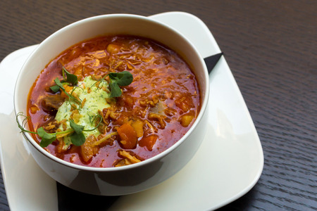 Goulash soup with lamb meat in a white plate on dark wooden table background closeupの写真素材