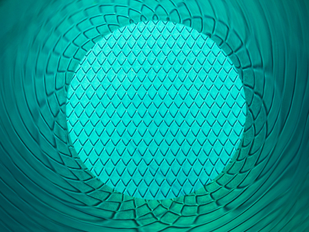 Background texture of cyan scales with copyspace in a circle with reflections in a tube with orange cornersの写真素材