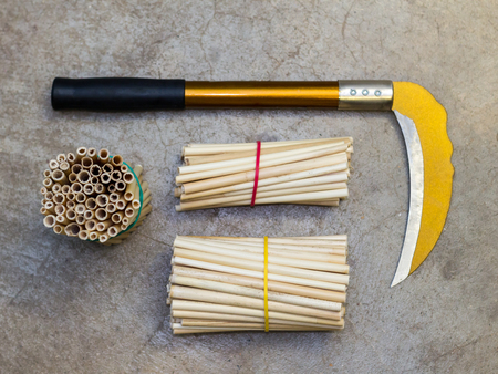 Yellow sickle with black handle on cracked concrete floor with copy spaceの写真素材