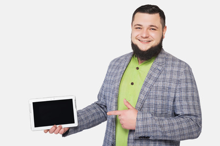 man with beard holds tablet in hand on white backgroundの写真素材