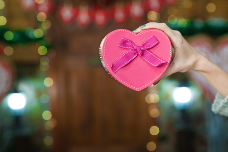 woman hand holding pink box in the form of heartの写真素材