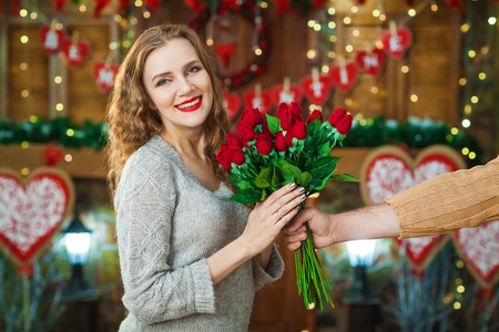 man hand gives woman bouquet of rosesの写真素材