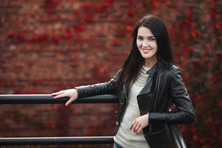 young girl in leather jacket and white pulloverの写真素材