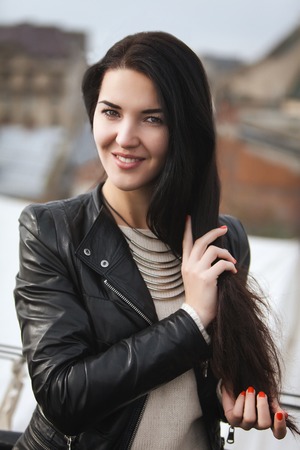 young girl in leather jacket and white pulloverの写真素材