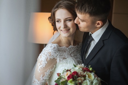 Groom hugs and kisses brideの写真素材