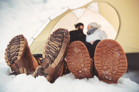 sole of winter shoes. Man and woman in camping tentの写真素材