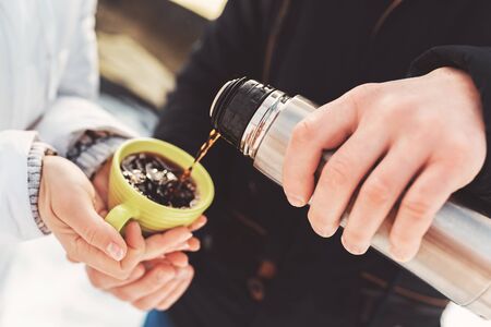 boy pour hot cacao to his girlfriend green cupの写真素材