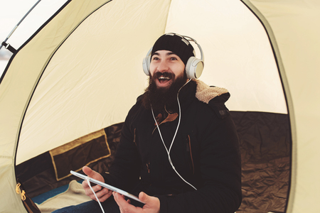 Bearded man with tablet watch movie and laughの写真素材
