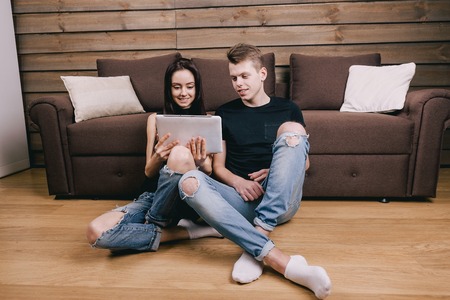 Couple at home websurfing with digital tabletの写真素材