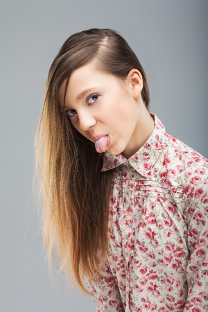 Cute young girl showing tongueの写真素材