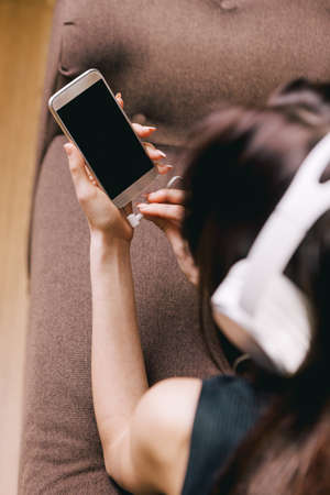 girl with headphones and cell phone at home
