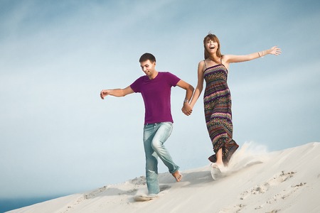 couple running from mountainの写真素材