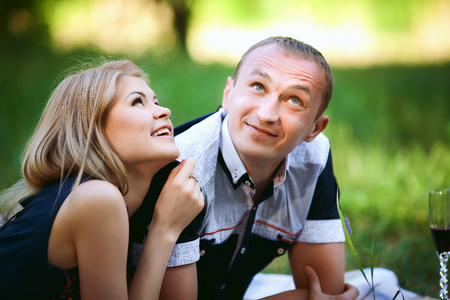 couple lying in grass and looking upの写真素材