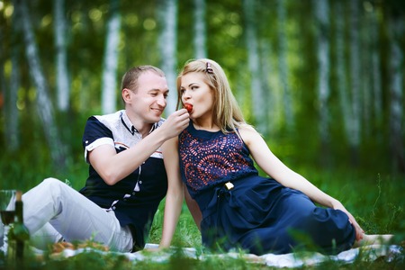 loving guy feeds a girl strawberriesの写真素材