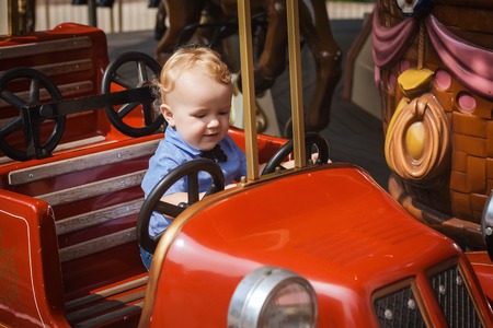 little boy is riding on the attractions in parkの写真素材