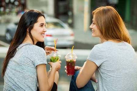 two girls drink cold cocktailsの写真素材