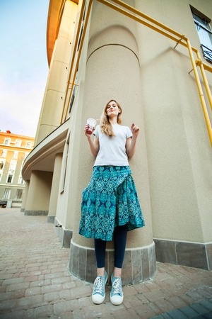 joyful girl walking around city with lemonadeの写真素材