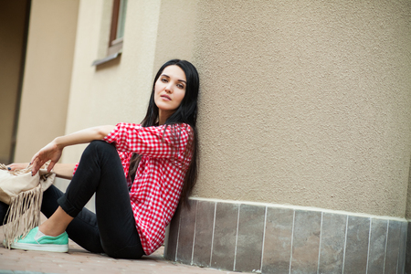 cute woman sitting on groundの写真素材