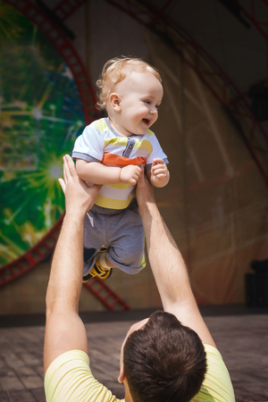 funny father holding his son over his headの写真素材