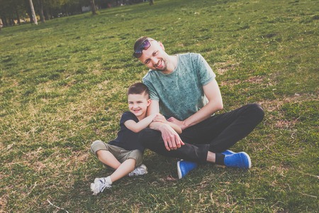 Dad with son having fun in the park. hipster style. casual clothes. concept of happy familyの写真素材