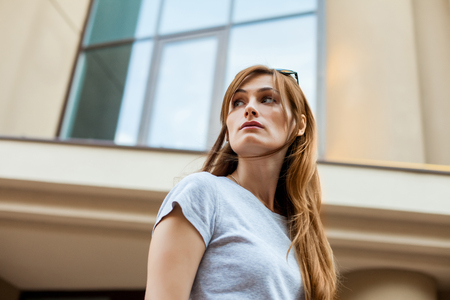 redhead hipster woman in a gray shirt walking in the street. Concept of modern freedom hipster human, close up portraitの写真素材
