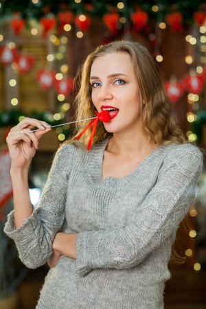 sexy girl in on valentines day. girl holding red heart - symbol of love in hand near mouth and smilingの写真素材