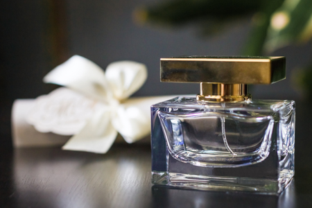 luxury perfume close up lying on the table near the white box with a bow.の写真素材