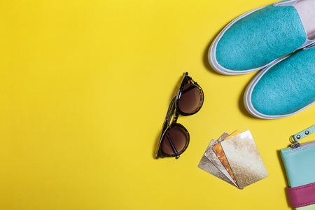Trendy clothes for girl. Fashion sunglasses, colored bag, aquamarine shoes, gold credit card and accessories. Concept of summer sale and shopping. Top viewの写真素材