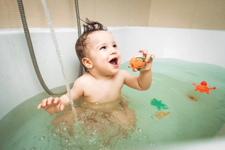 Cute beauty happy little baby boy washing in bathroom with toys, childs hygiene, healthy lifestyle,...