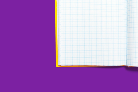 white opened workbook lying on a purple background. concept of business or educational equipmentの写真素材